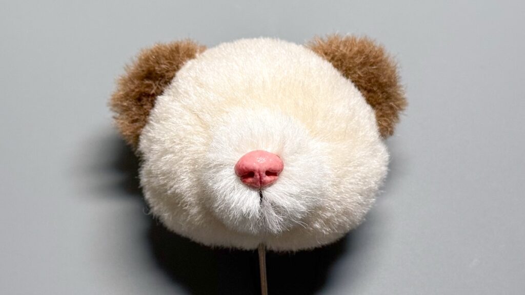 口の刺繍と鼻を付けたテディベアの顔